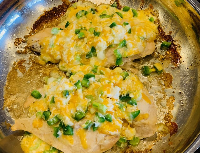 Jalapeno cheddar chicken in a stainless steel skillet. 