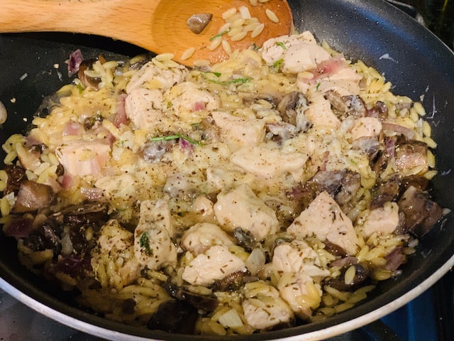 Parmesan herb chicken and mushroom with orzo in the skillet. 